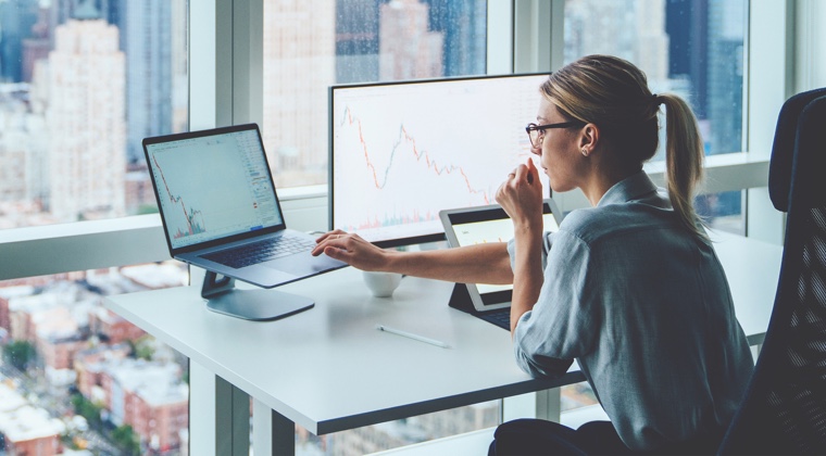 Woman in front of computer screens at desk in office photo