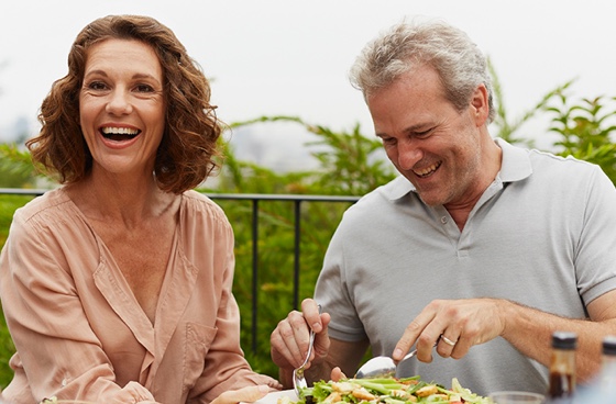 Smiling couple eating dinner on a patio