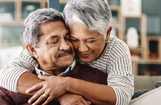 Elderly man and woman hugging in a home setting photo