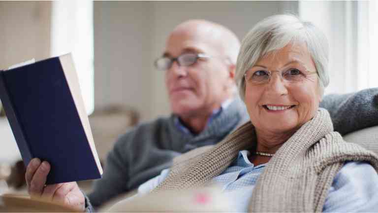 An older couple sitting and reading together