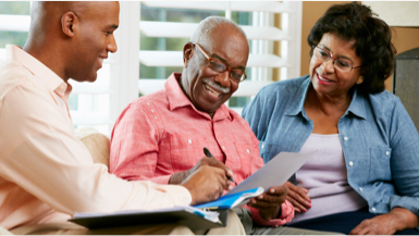 A picture of an advisor going over paperwork with an older couple