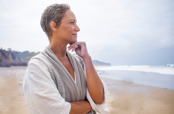 A picture of an older woman standing on a beach